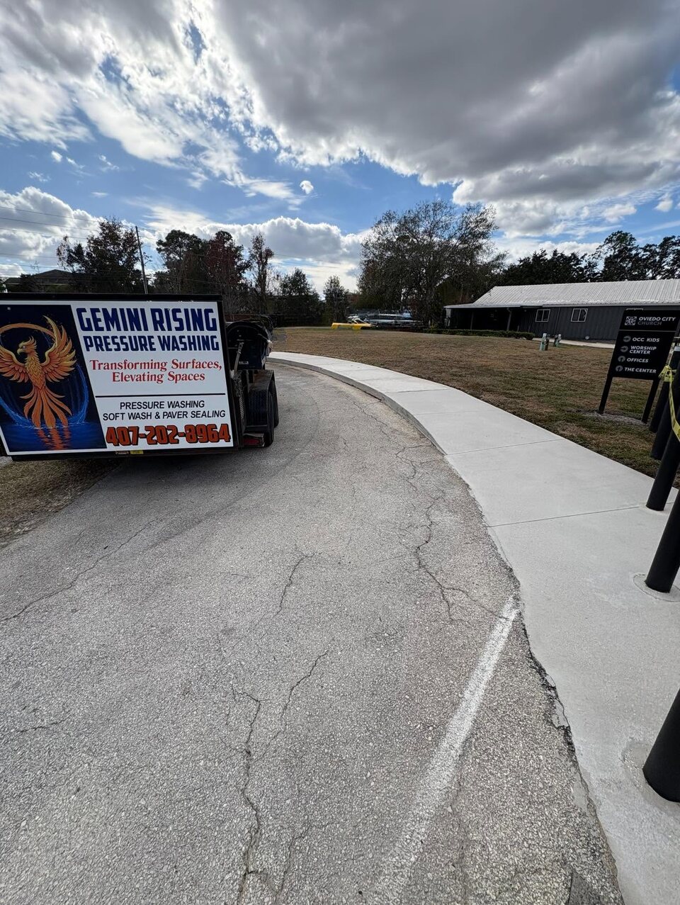 Gemini Rising branded trailer beside a freshly whitened sidewalk at Oviedo City Church