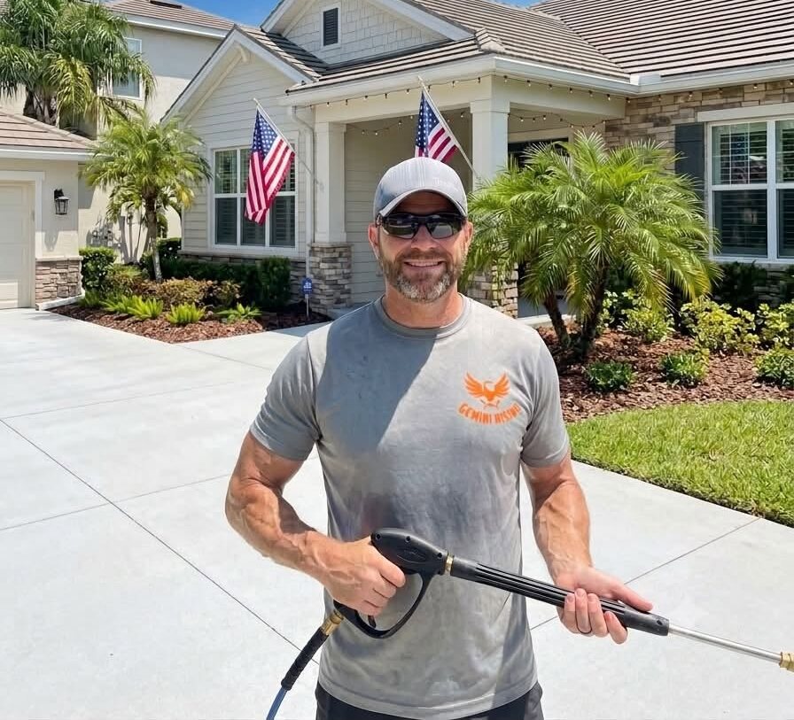 Dan of Gemini Rising Pressure Washing smiling in front of a freshly washed Central Florida home, holding his pressure washing wand