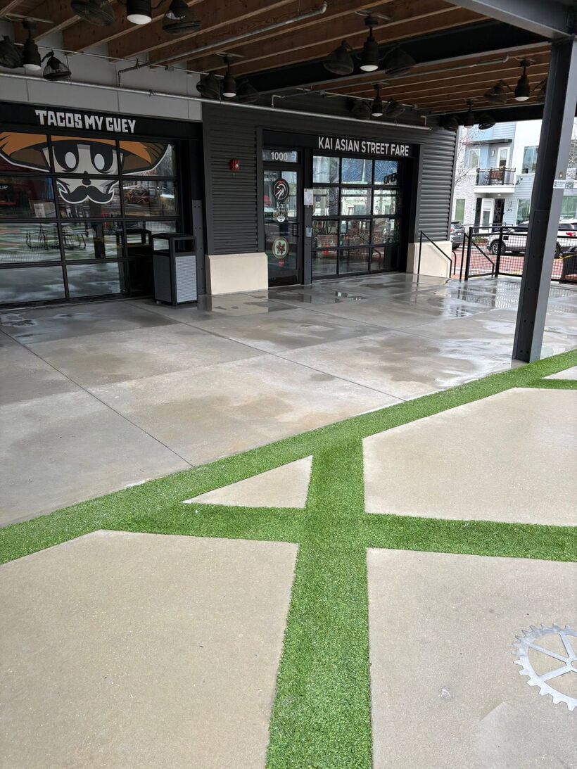 Clean storefront patios and turf stripes in front of Tacos My Guey and Kai Asian Street Fare