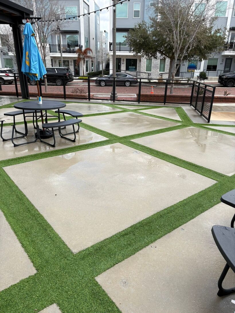 Turf-grid courtyard with cafe tables, spotless after pressure washing